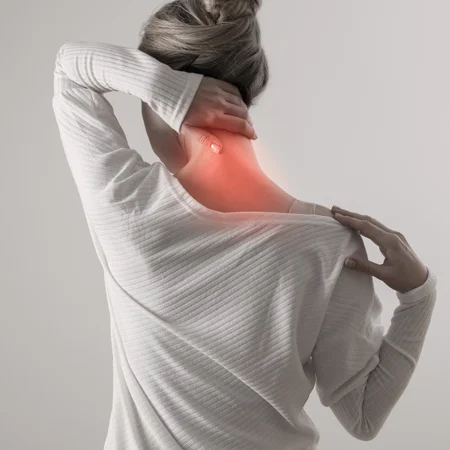 A woman holding onto her neck in pain