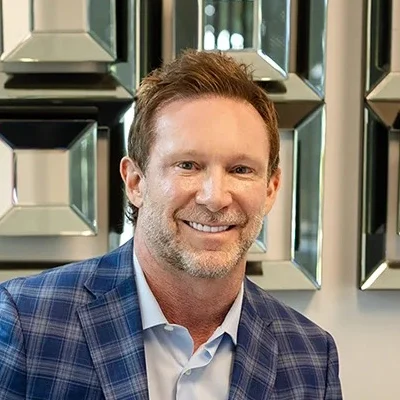 John East smiling in a suit.