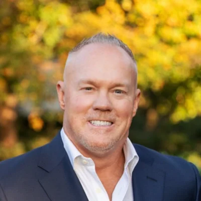Chiropractor Jason Black Smiling Outdoors Among Yellow Leaves
